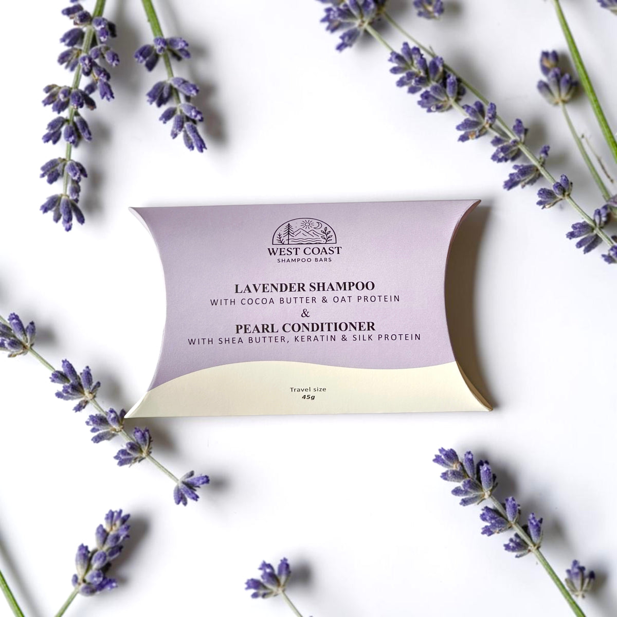 West Coast Shampoo Bars Lavender Shampoo and Pearl Conditioner travel size box, styled with lavender sprigs on a white background.