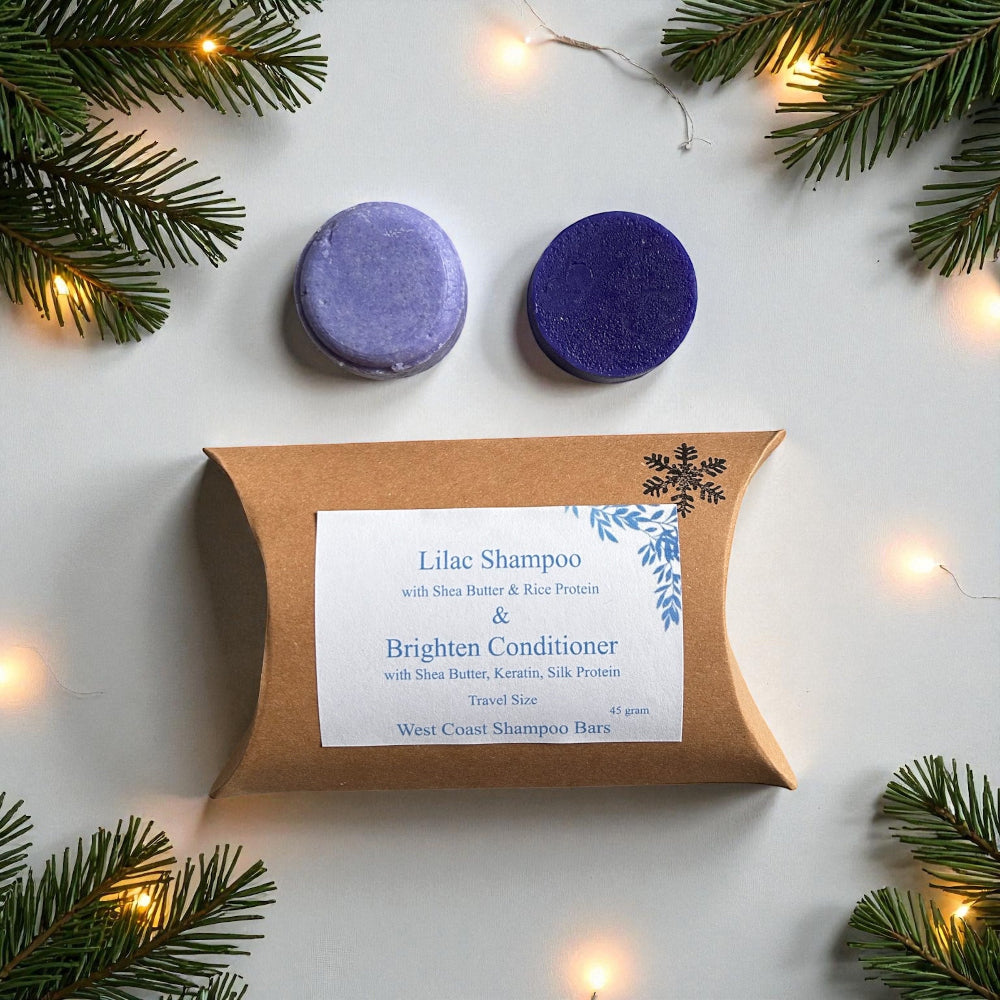 Two purple shampoo bars with a brown packaging box labeled 'Lilac Shampoo & Brighten Conditioner' on a white background with Christmas decorations.