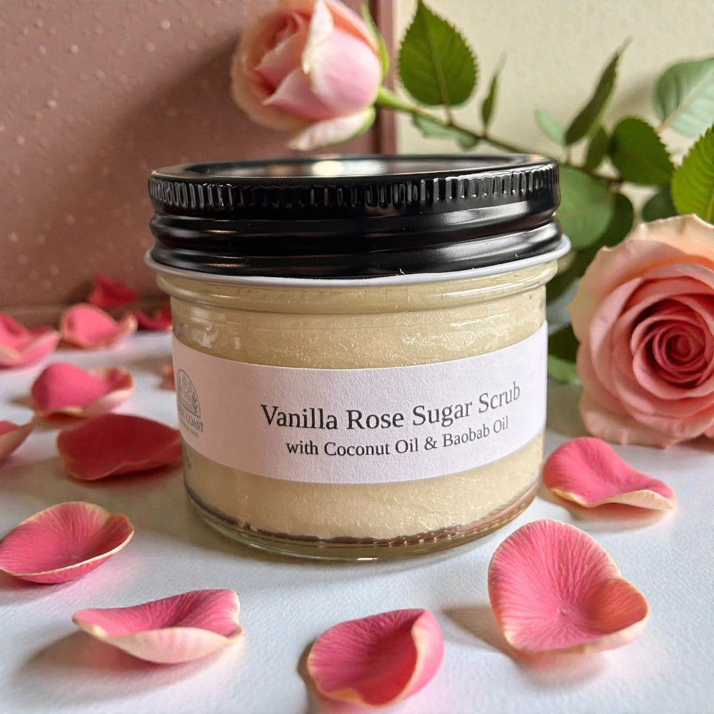 Jar of Vanilla Rose Sugar Scrub with pink roses and petals on a light background